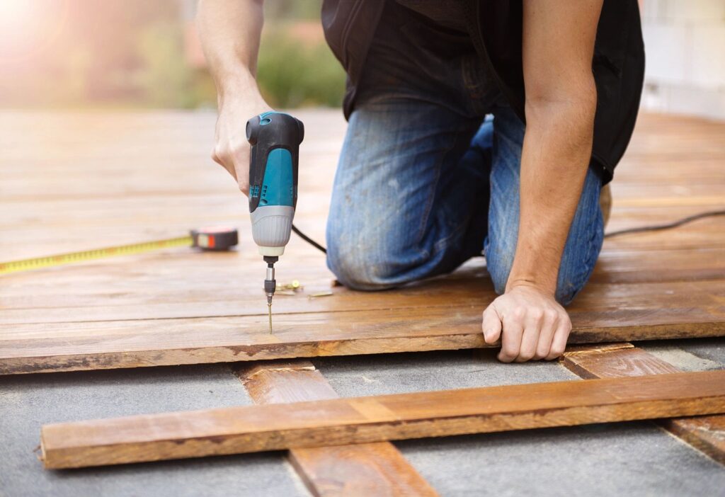 a man using a drill to drill a wood plank