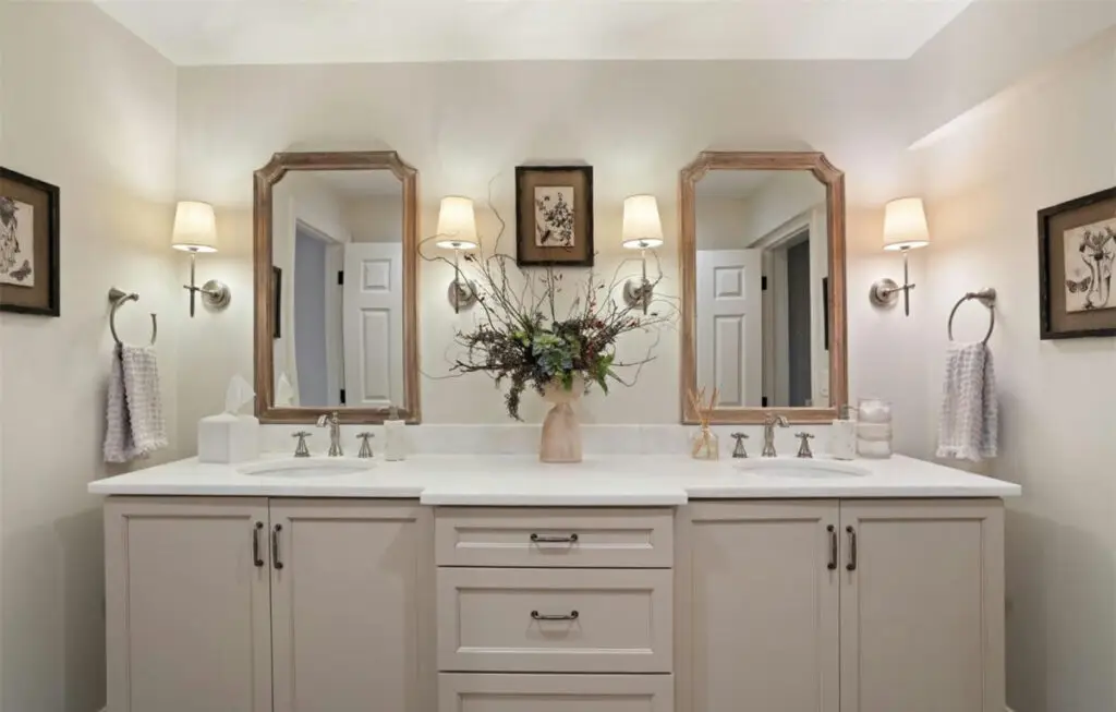 a bathroom with a vase of flowers and mirrors