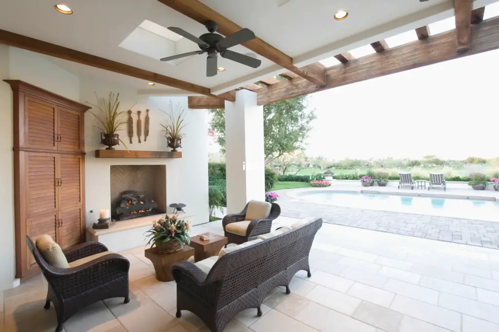 a patio with a fireplace and chairs