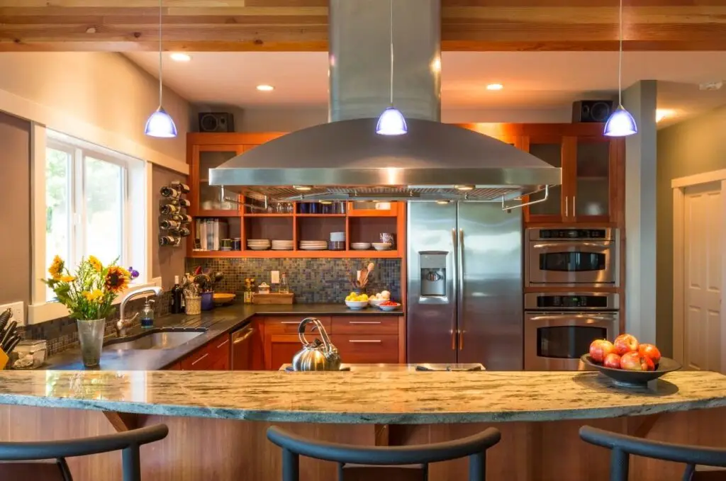 a kitchen with a large island and stainless steel appliances